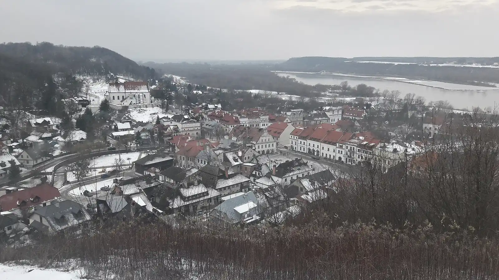 Zaśnieżone dachy Kazimierza Dolnego i dolina Wisły widziane z Góry Trzech Krzyży
