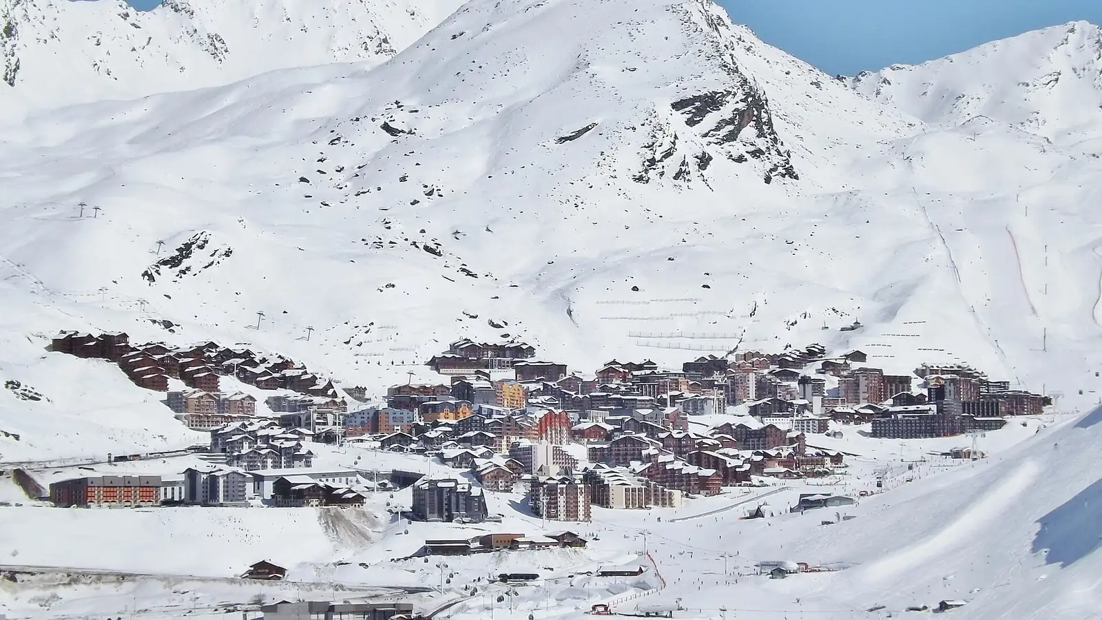 Zabudowa ośrodka Val Thorens na ośnieżonym zboczu pod szczytami Alp w słoneczny zimowy dzień