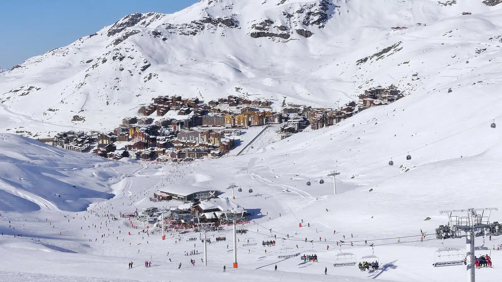 Rozległe ośnieżone stoki z wyciągami nad zabudową Val Thorens, w dole kolej krzesełkowa