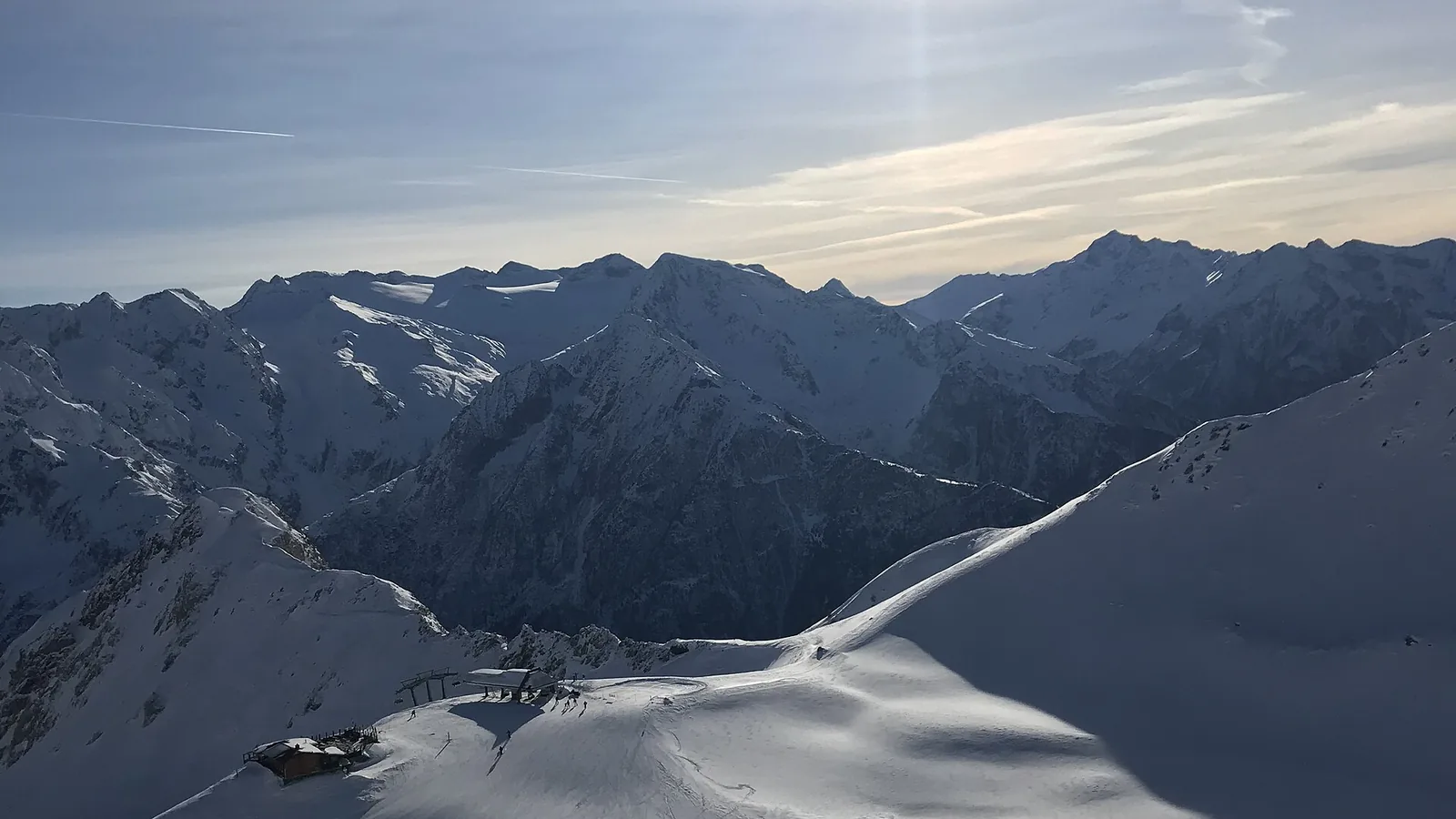 Zaśnieżone szczyty Alp nad ośnieżonym grzbietem w ośrodku Passo del Tonale, przy kolei Giuliana